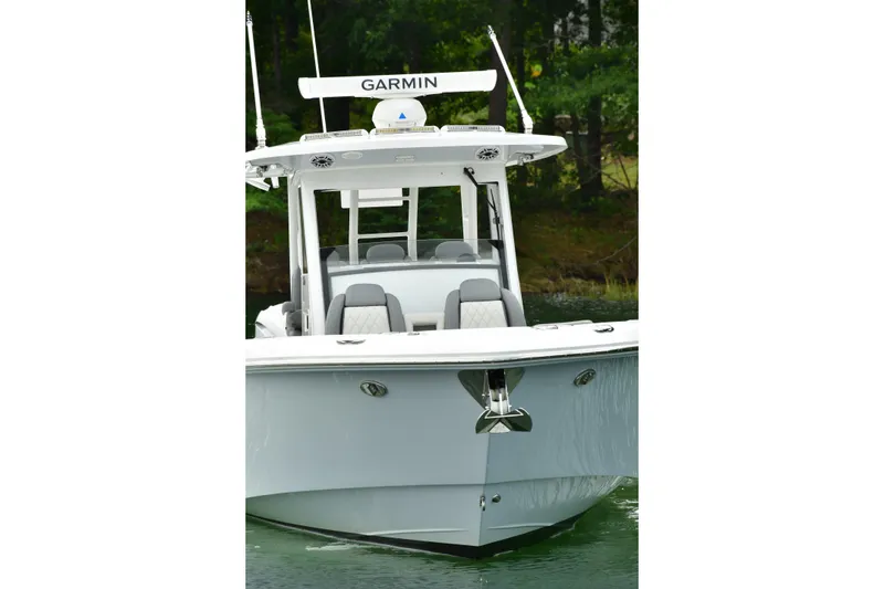 Slide: The Image of 2022 Everglades 335 Center Console boat on water, front view with Garmin equipment. - 2