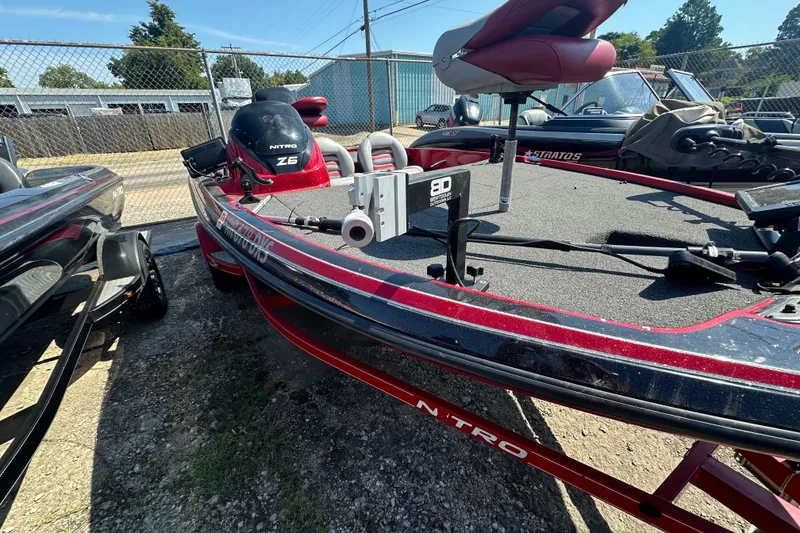 Slide: The Image of 2011 Nitro Z-6 boat with red and black detailing, parked outdoors. - 11