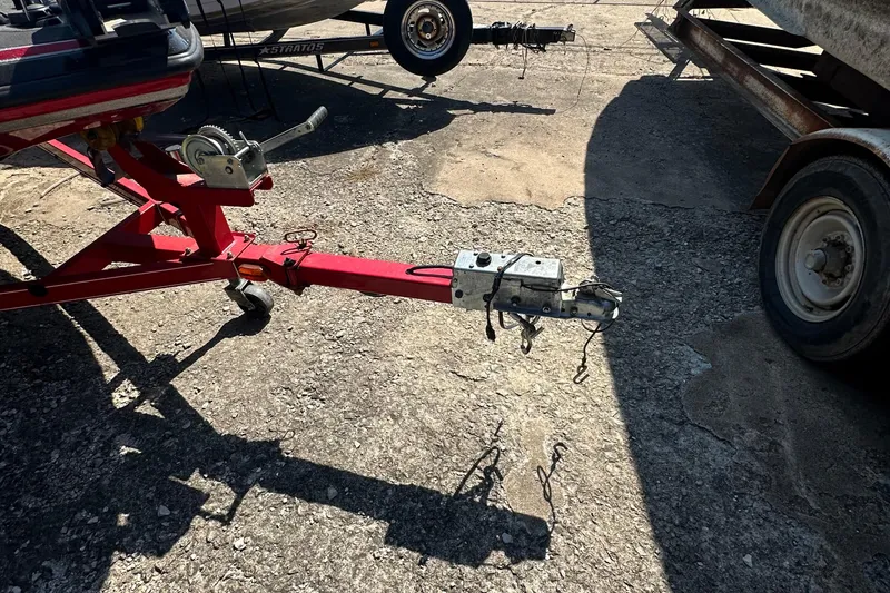 Slide: The Image of Red trailer hitch of a 2011 Nitro Z-6 boat on a gravel surface. - 13