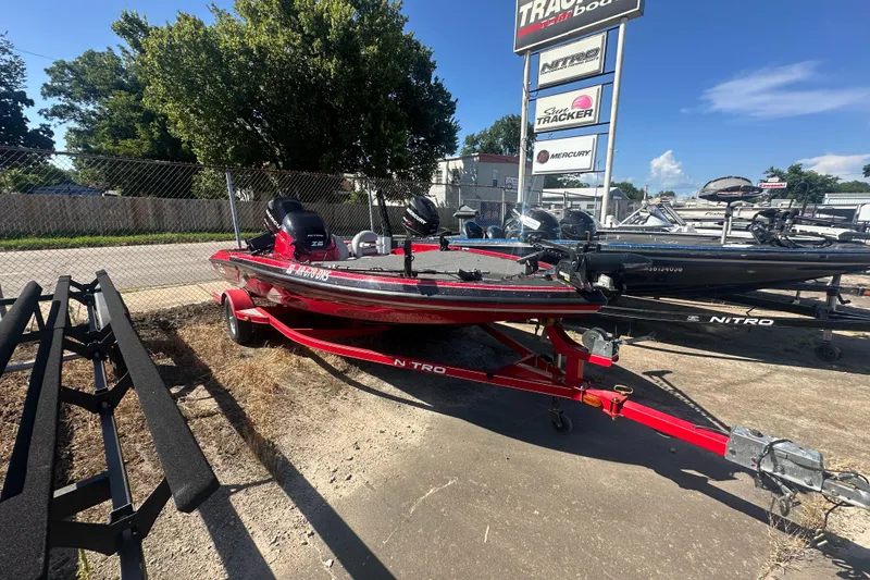 Slide: The Image of 2011 Nitro Z-6 boat on red trailer at dealership, sunny day. - 14