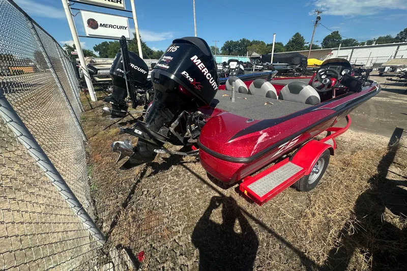 Slide: The Image of Red 2011 Nitro Z-6 boat with Mercury engine, parked near a fence. - 16