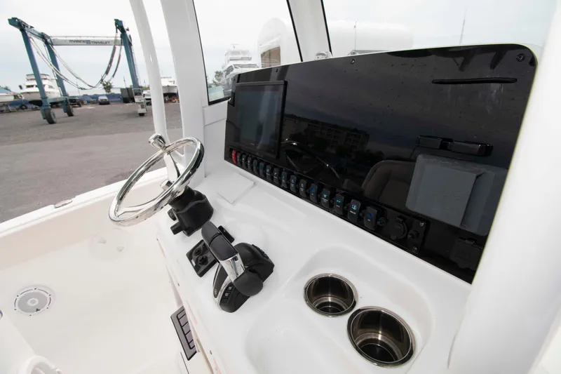 Slide: The Image of 2023 Sea Hunt Ultra 265 SE boat dashboard with steering wheel and control panel. - 12