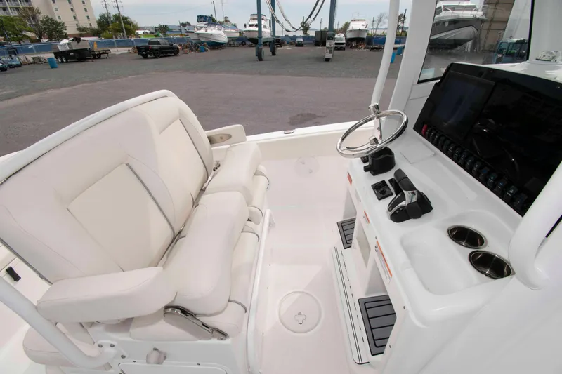 Slide: The Image of 2023 Sea Hunt Ultra 265 SE boat interior with helm, steering wheel, and seating. - 13