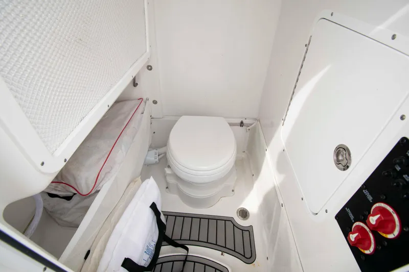 Slide: The Image of 2023 Sea Hunt Ultra 265 SE boat interior with compact marine toilet and storage. - 18