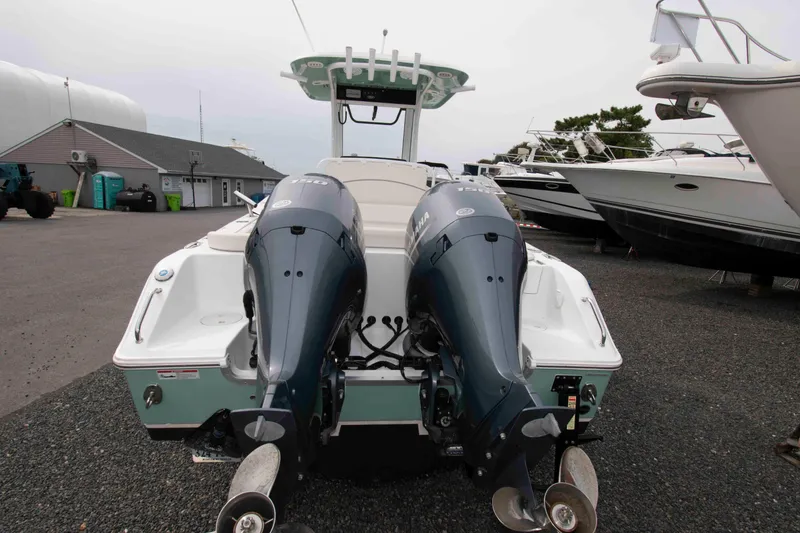 Slide: The Image of 2023 Sea Hunt Ultra 265 SE boat with dual outboard motors in a marina setting. - 19