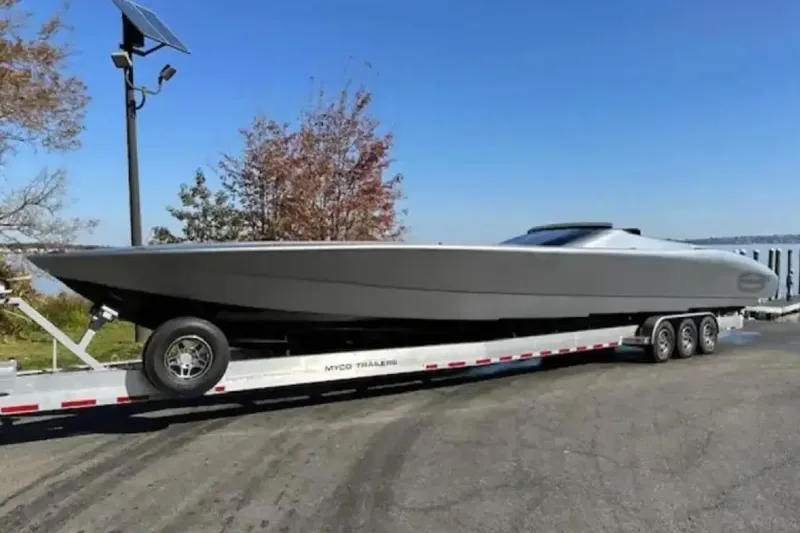 Slide: The Image of 2020 Outerlimits SL-50 powerboat on trailer, parked outdoors under clear sky. - 11