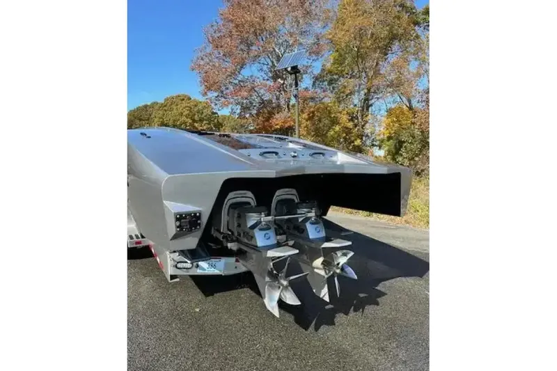 Slide: The Image of 2020 Outerlimits SL-50 boat with dual propellers, parked on a trailer, surrounded by autumn trees. - 12