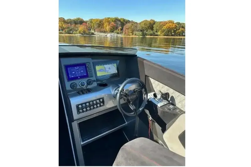 Slide: The Image of 2020 Outerlimits SL-50 boat cockpit with modern navigation system and steering wheel on a calm lake. - 5