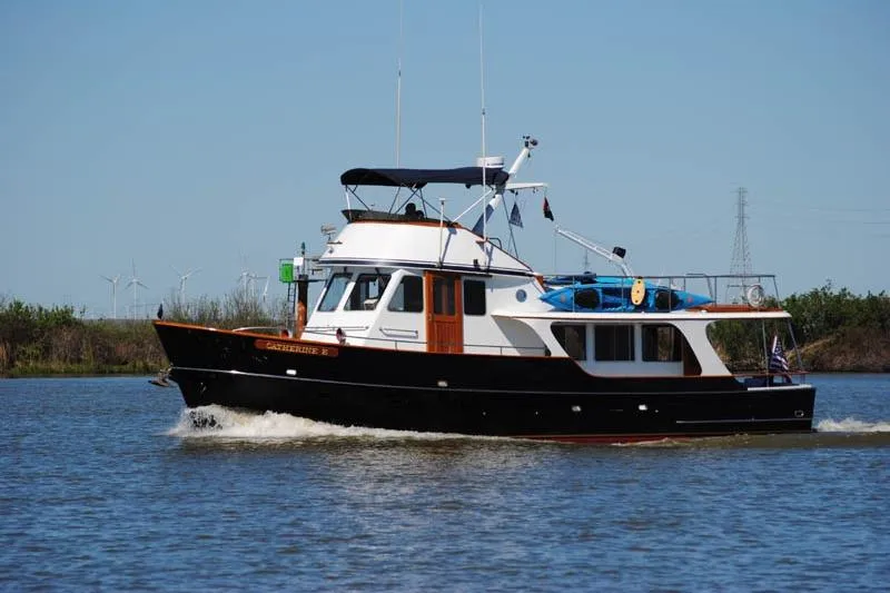 Slide: The Image of 1989 Custom 52 Pilothouse boat cruising on a calm river under clear blue skies. - 2