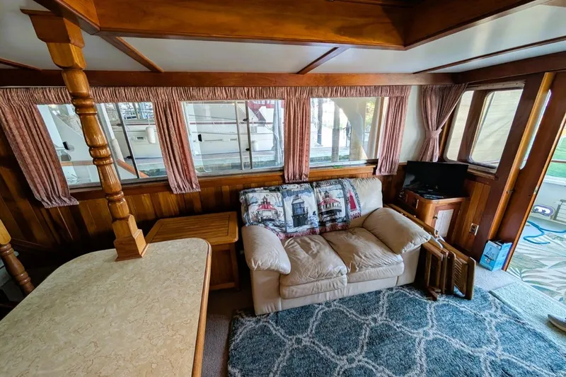 Slide: The Image of Cozy interior of 1989 Custom 52 Pilothouse with sofa, nautical decor, and wood paneling. - 25