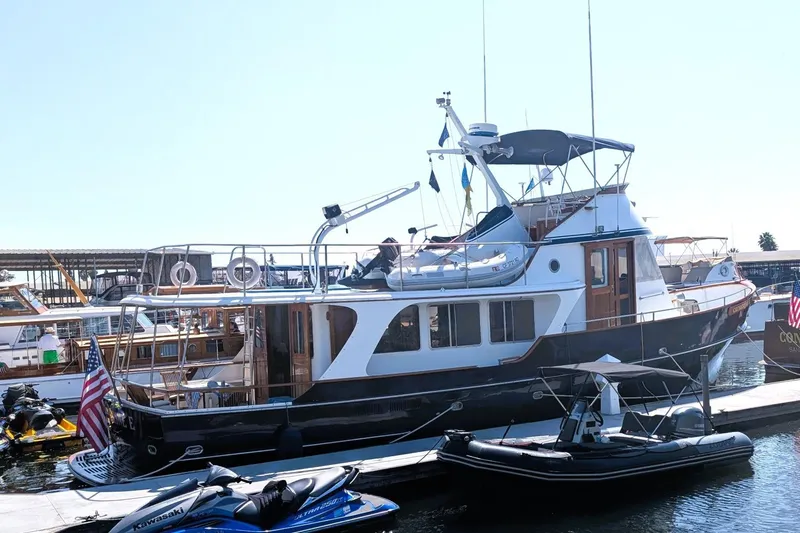 Slide: The Image of Custom 1989 52 Pilothouse yacht docked with jet skis nearby. - 3