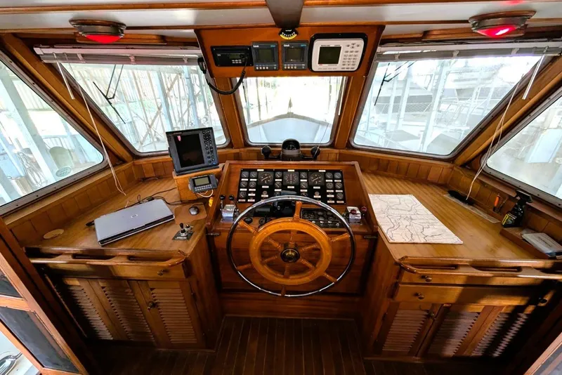 Slide: The Image of 1989 Custom 52 Pilothouse interior with wooden helm, navigation equipment, and nautical chart. - 30