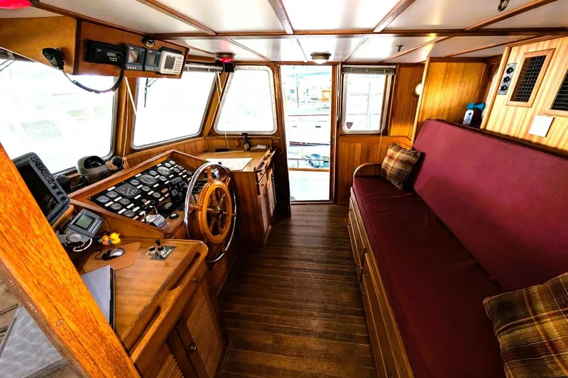 Slide: The Image of 1989 Custom 52 Pilothouse interior with wooden helm, instruments, and maroon seating. - 31