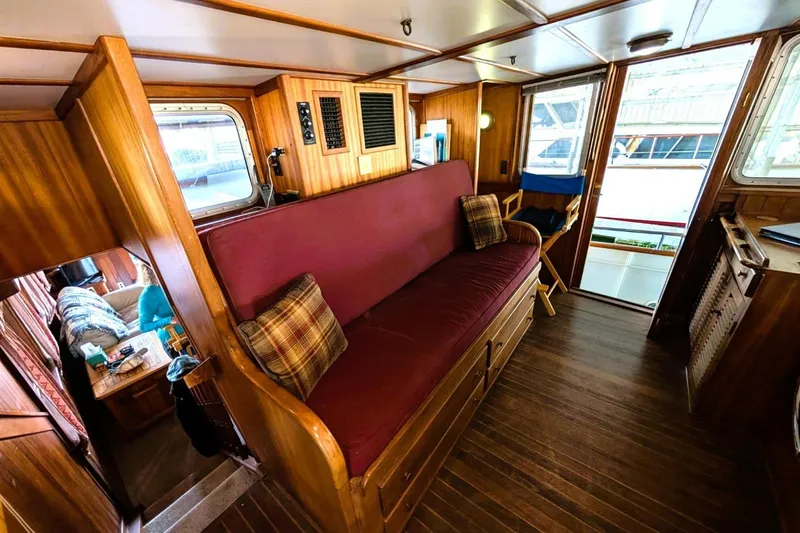 Slide: The Image of Interior of 1989 Custom 52 Pilothouse with wooden paneling and maroon seating. - 33