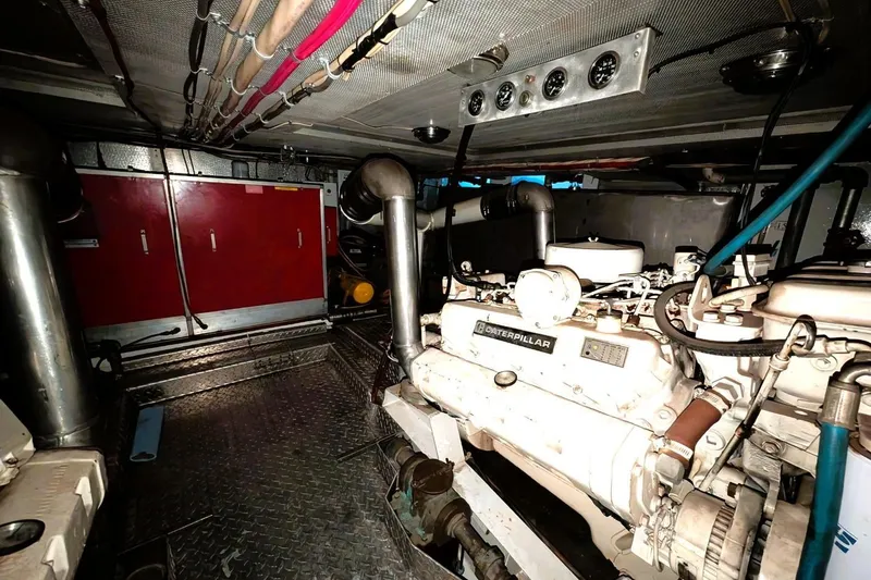 Slide: The Image of Engine room of a 1989 Custom 52 Pilothouse with Caterpillar machinery and red storage cabinets. - 37
