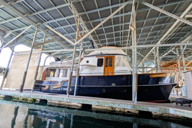Slide: The Image of 1989 Custom 52 Pilothouse boat docked in a covered marina. - 38