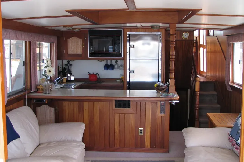 Slide: The Image of Interior of 1989 Custom 52 Pilothouse with wooden kitchen and cozy seating area. - 4