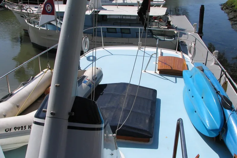 Slide: The Image of 1989 Custom 52 Pilothouse yacht deck with kayaks and inflatable boats docked at marina. - 8