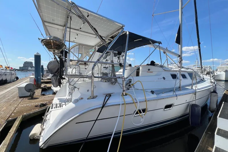 The Image of 2005 Hunter 44 Deck Salon yacht docked at marina under clear blue sky. - 0