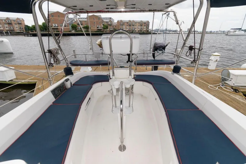 Slide: The Image of 2005 Hunter 44 Deck Salon sailboat cockpit with blue seating, docked at marina. - 10