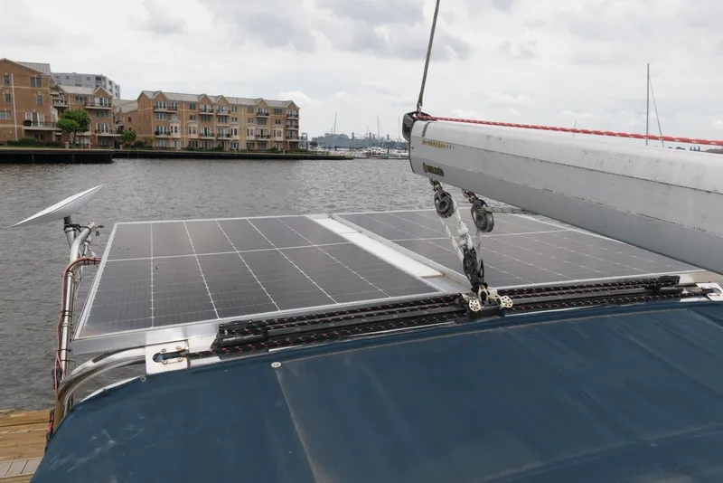 Slide: The Image of Hunter 44 Deck Salon 2005 sailboat with solar panels, docked near waterfront buildings. - 15