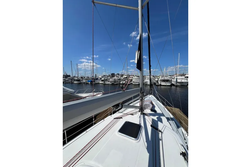Slide: The Image of 2005 Hunter 44 Deck Salon sailboat docked in a marina under a clear blue sky. - 17