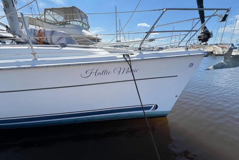 Slide: The Image of 2005 Hunter 44 Deck Salon sailboat docked in marina, clear sky background. - 22