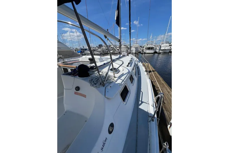 Slide: The Image of 2005 Hunter 44 Deck Salon sailboat docked at marina under clear blue sky. - 24