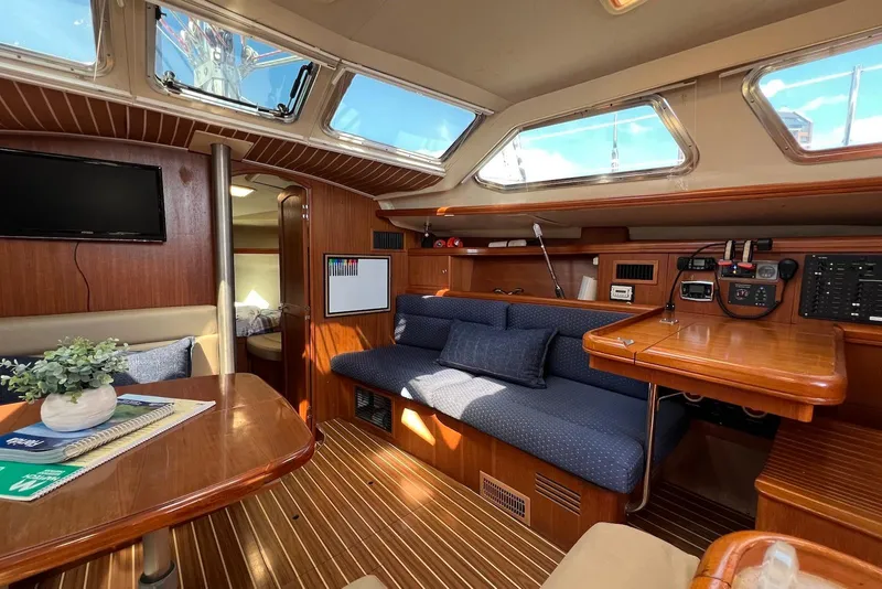 Slide: The Image of Interior of 2005 Hunter 44 Deck Salon yacht with wood finish and blue seating. - 26