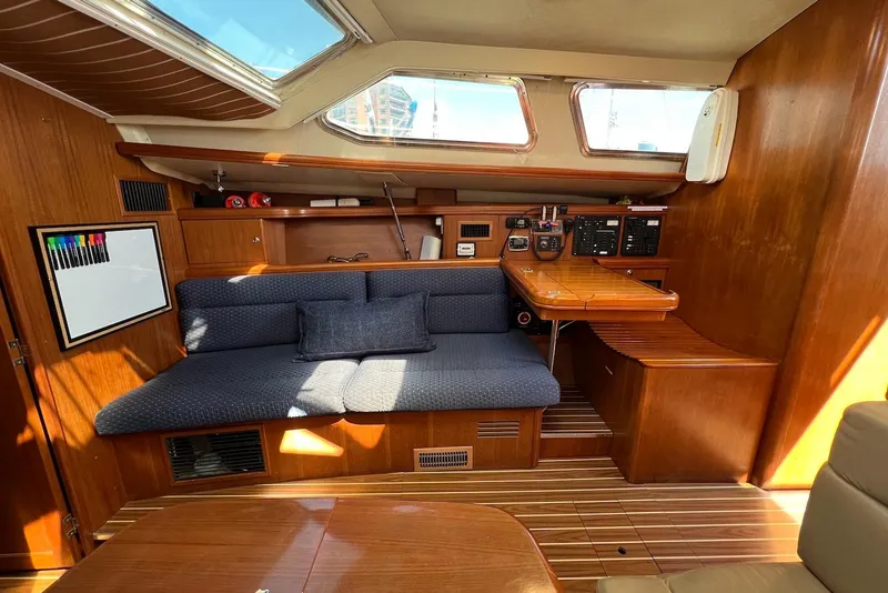 Slide: The Image of Interior of 2005 Hunter 44 Deck Salon with wooden finish and blue seating. - 28