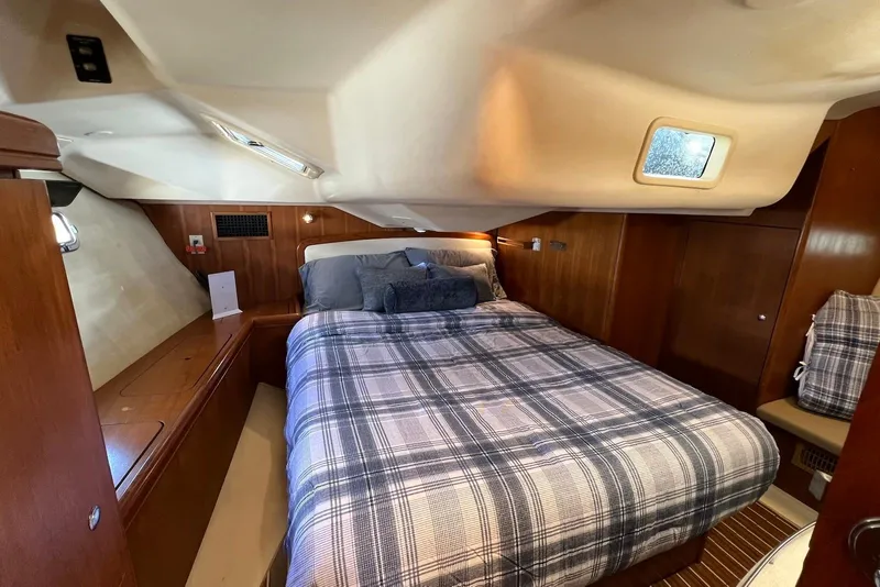 Slide: The Image of Cozy cabin interior of 2005 Hunter 44 Deck Salon with plaid bedding and wooden accents. - 35