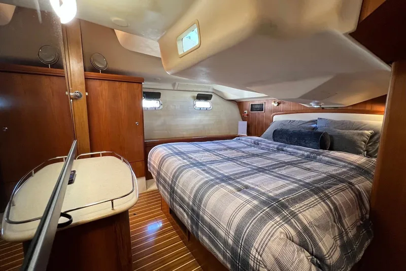 Slide: The Image of Luxurious cabin interior of 2005 Hunter 44 Deck Salon with cozy bed and wooden accents. - 36