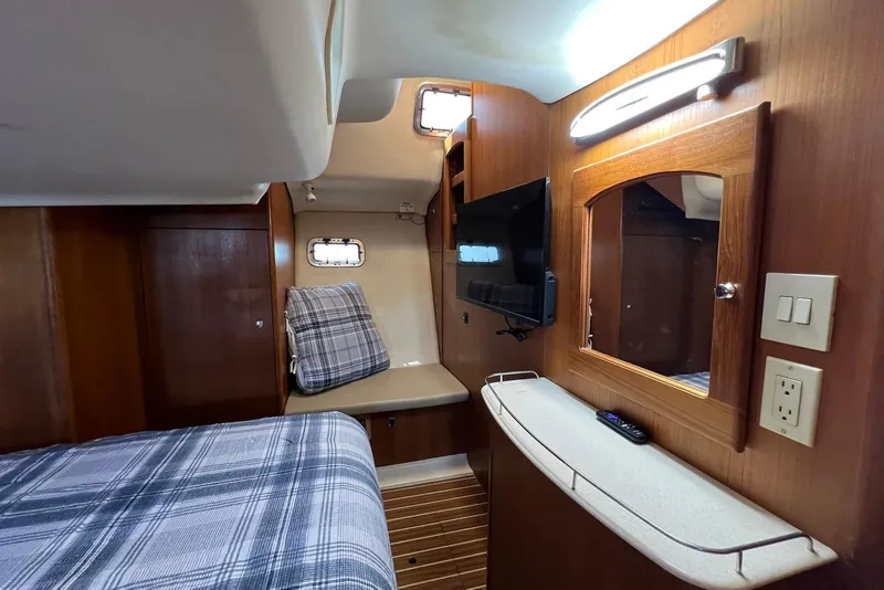 Slide: The Image of Interior of 2005 Hunter 44 Deck Salon with wood paneling, bed, TV, and mirror. - 38
