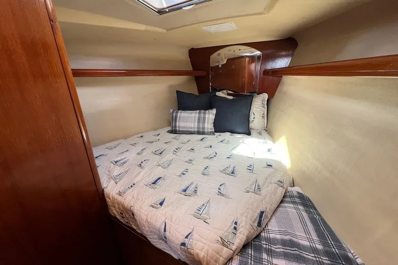 Slide: The Image of Cozy cabin interior of 2005 Hunter 44 Deck Salon with nautical-themed bedding. - 43