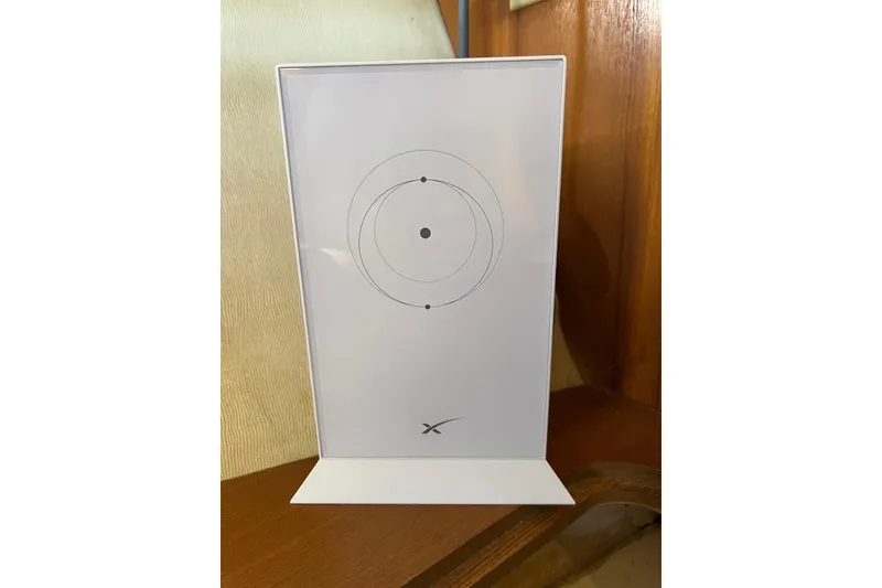 Slide: The Image of White target board with concentric circles, displayed on a wooden surface. - 47