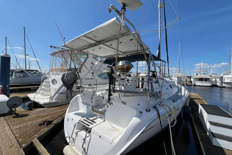Slide: The Image of 2005 Hunter 44 Deck Salon yacht docked at marina under clear blue sky. - 5