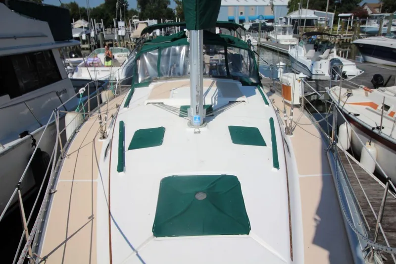 Slide: The Image of 1991 Hunter 37.5 sailboat docked at marina, featuring green accents and spacious deck. - 4