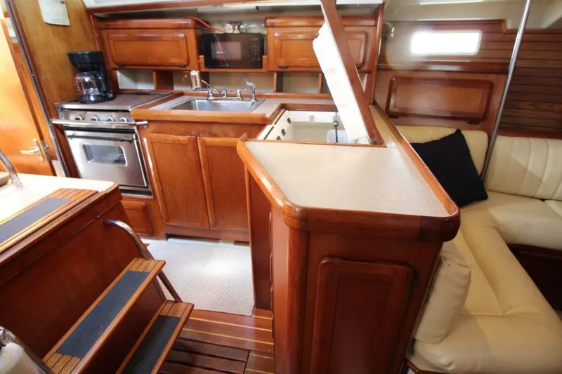 Slide: The Image of Interior of 1991 Hunter 37.5 sailboat with wooden cabinetry and compact kitchen. - 8