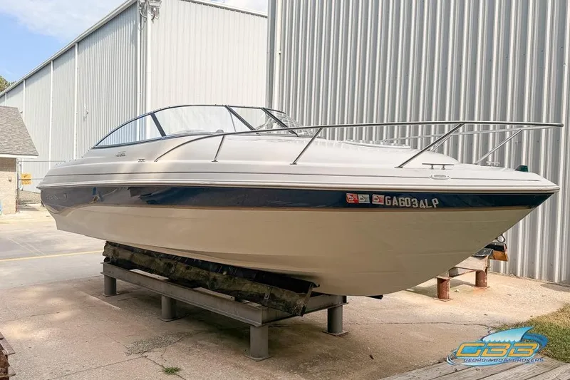 The Image of 1998 Monterey 236 Montura boat on a stand, near a metal building. - 0