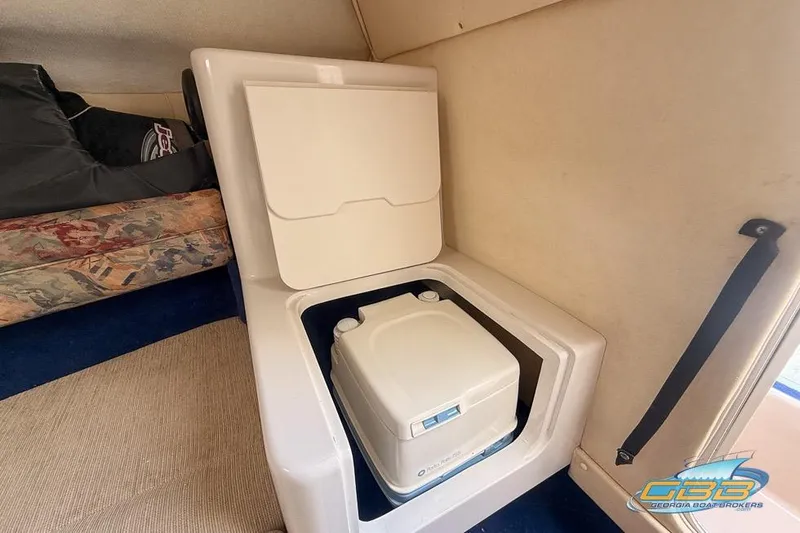 Slide: The Image of 1998 Monterey 236 Montura boat interior with portable toilet and seating area. - 10