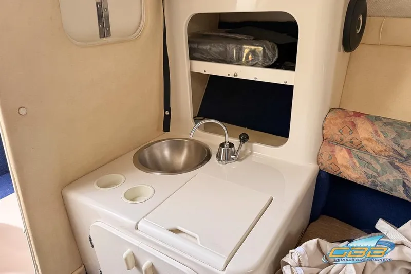 Slide: The Image of 1998 Monterey 236 Montura boat interior with sink and storage area. - 11
