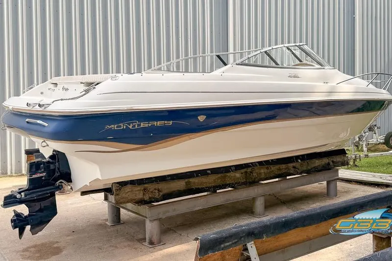 Slide: The Image of 1998 Monterey 236 Montura boat on a stand, blue and white exterior. - 4