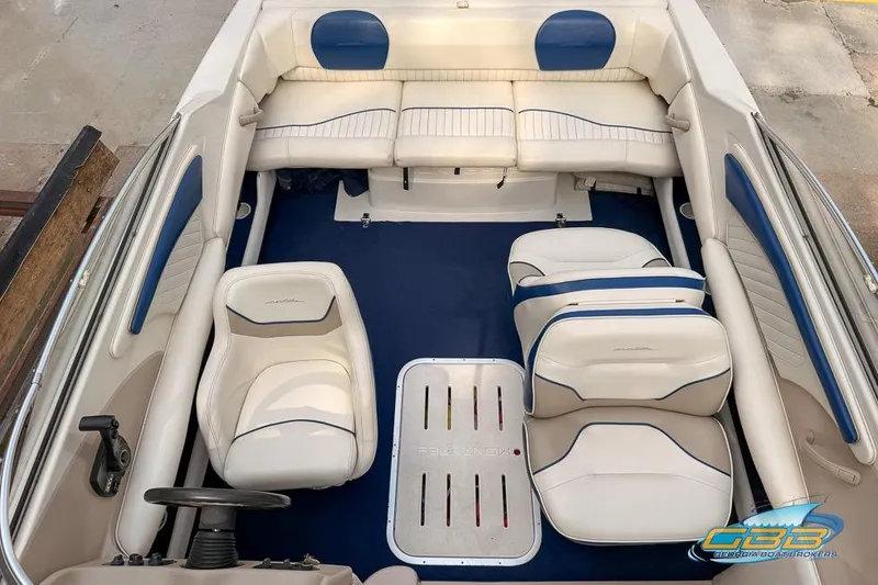 Slide: The Image of 1998 Monterey 236 Montura boat interior with white and blue seating, steering wheel, and carpet. - 6