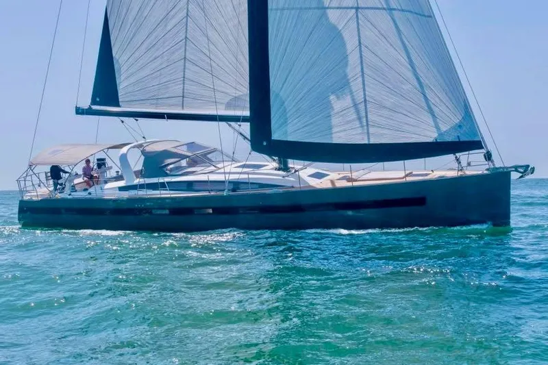 Slide: The Image of 2017 Jeanneau 64 sailboat cruising on open water under clear blue skies. - 1