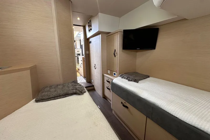 Slide: The Image of Luxurious cabin interior of 2017 Jeanneau 64 yacht with twin beds and TV. - 101