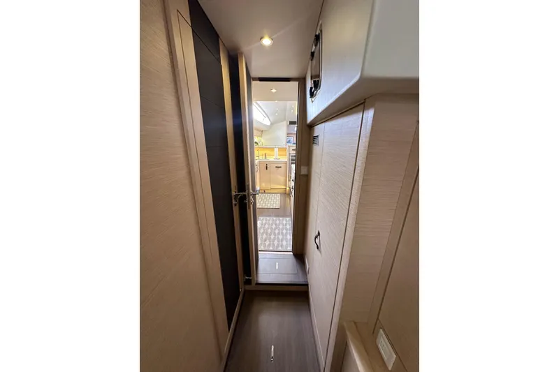 Slide: The Image of Interior hallway of 2017 Jeanneau 64 yacht, featuring modern wood paneling and sleek design. - 102
