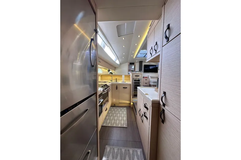 Slide: The Image of Luxurious interior of a 2017 Jeanneau 64 yacht, featuring a modern kitchen design. - 103