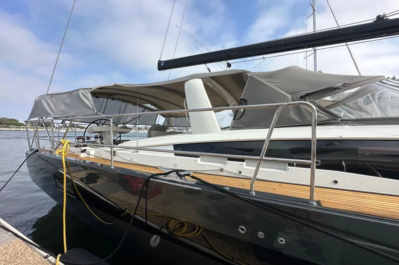 Slide: The Image of 2017 Jeanneau 64 yacht docked, featuring sleek design and covered deck. - 11