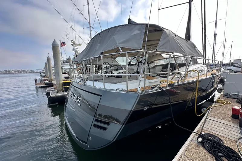 Slide: The Image of 2017 Jeanneau 64 yacht docked at marina, featuring sleek design and covered deck. - 12