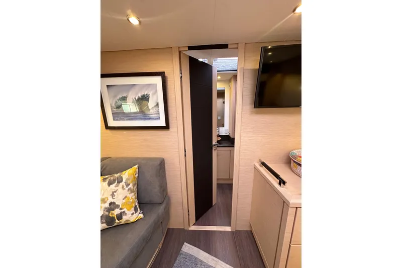 Slide: The Image of Interior of 2017 Jeanneau 64 yacht with modern decor and open door to bathroom. - 120